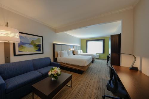 a hotel room with a bed and a couch at Holiday Inn Express & Suites Santa Clara - Silicon Valley, an IHG Hotel in Santa Clara