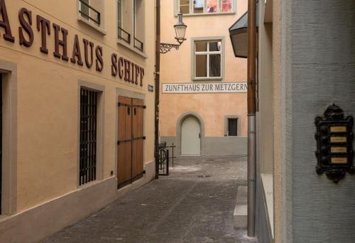 eine leere Gasse mit einem Schild an einem Gebäude in der Unterkunft HITrental Zur Metzgern Apartments in Luzern