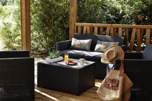 d'une terrasse avec 2 chaises en osier et une table. dans l'établissement Résidence & Hotel U Livanti ECOLABEL, à Propriano