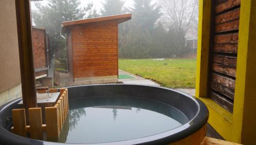 eine große Badewanne in einem Zimmer mit Fenster in der Unterkunft Pajkos Póni Vendégház in Miskolc