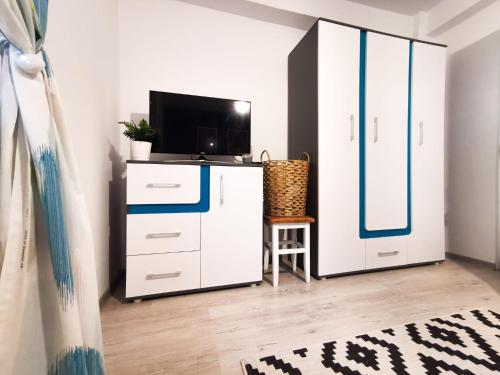 - un salon avec une télévision et une armoire blanche dans l'établissement 105500 Apartment, à Buşteni