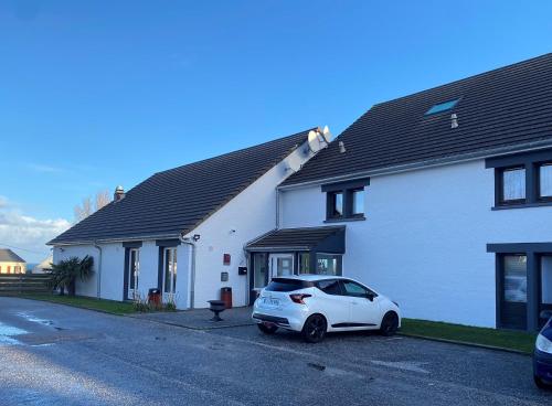 een witte auto geparkeerd voor een huis bij SHELDER Hôtel - CHERBOURG EN COTENTIN - Equeurdreville in Cherbourg en Cotentin