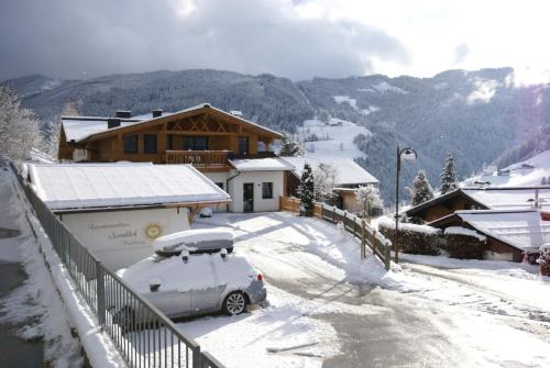 een auto geparkeerd in de sneeuw voor een huis bij Hochkönig Ferien in Mühlbach am Hochkönig