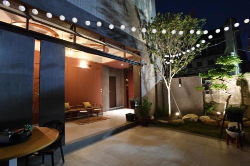 a courtyard with a table and chairs and lights at Fu's house 52 in Tainan