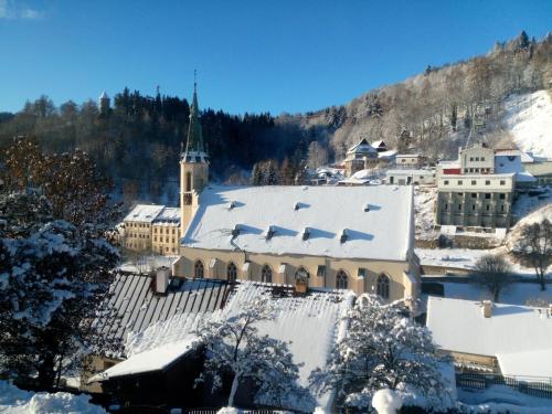 een kerk met een met sneeuw bedekt dak in een stad bij Apartmán Albreit 1 in Jáchymov