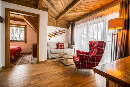 - un salon avec un canapé et une chaise dans l'établissement Gościniec Kuźnice, à Zakopane