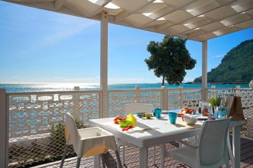 einen Tisch und Stühle auf einer Terrasse mit Meerblick in der Unterkunft Le Palme Village in Terracina