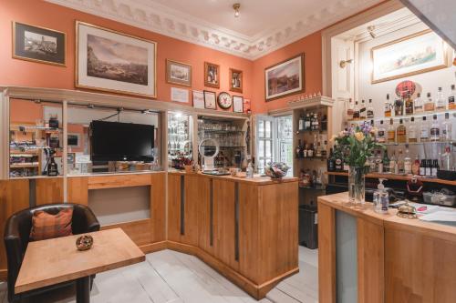 een bar met een televisie en een bureau in een kamer bij Hotel Ceilidh-Donia in Edinburgh