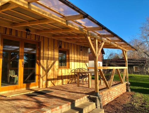 una terraza de madera con una mesa en una casa en Rīga Mangalsala Cottage with sauna, en Riga