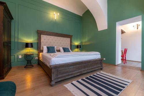 1 dormitorio con cama y pared verde en Apartment Green, en Sibiu