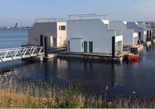 a building on a dock on a body of water at Schwimmendes Ferienhaus Swimming Lounge in Kappeln