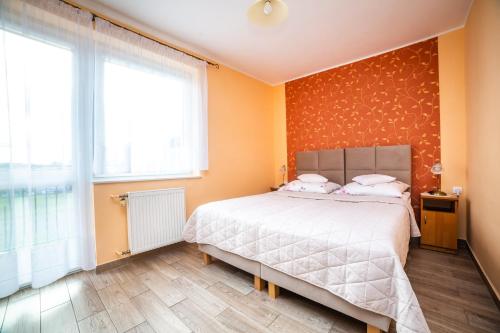 a bedroom with a large bed with orange walls at Dom Wczasowy Grażyna in Władysławowo