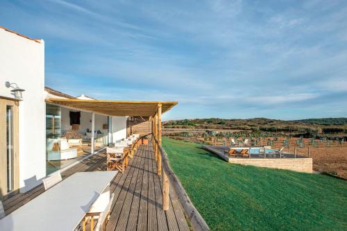 eine Außenterrasse mit Blick auf ein Grasfeld in der Unterkunft Hortas do Rio - Casa de Campo in Carrapateira