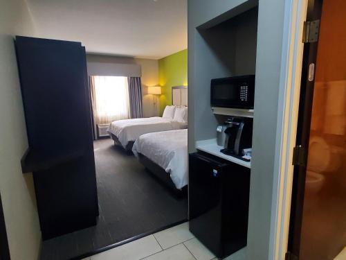 une chambre d'hôtel avec un lit et une télévision dans l'établissement Holiday Inn Express Pearland, an IHG Hotel, à Pearland