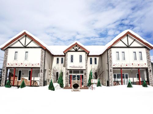 ein Bild eines Hauses mit Schnee in der Unterkunft Petit Hotel Blaneneige in Nakafurano