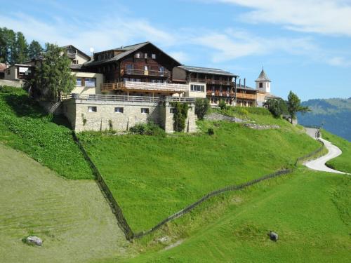 une maison au sommet d'une colline avec une route dans l'établissement Hotel Restaurant Capricorns, à Wergenstein