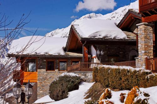 una casa cubierta de nieve con una montaña en el fondo en Les Combes, en La Salle