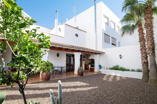 - une vue sur l'extérieur d'une maison blanche avec des palmiers dans l'établissement Ses Àmfores, à Ciutadella