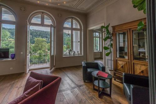 - un salon avec des chaises, une table et des fenêtres dans l'établissement Albergo-Toscana, à Bad Schandau