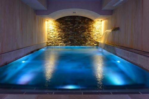 una piscina azul en una habitación con una pared de piedra en Ville Sull'Arno, en Florencia