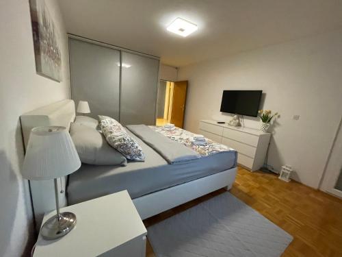 Dormitorio pequeño con cama y TV en DIS apartment Varaždin, en Varaždin