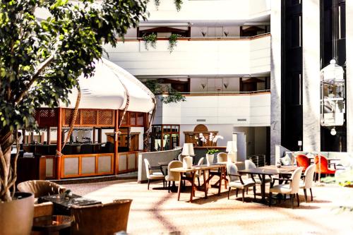 a patio with tables and chairs and a building at Rahat Palace Hotel in Almaty