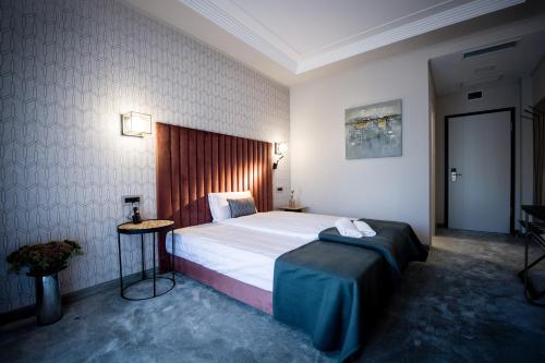 a hotel room with a large bed and a table at Pensiunea Nora Prestige in Timişoara