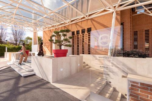 a building with a glass roof with a person sitting on a table at GHV Hotel in Vicenza