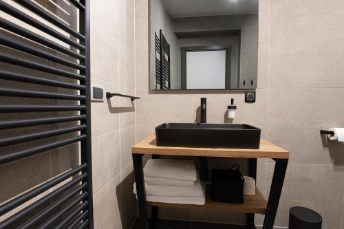 a bathroom with a black sink and a mirror at SAVOY residence in Osijek