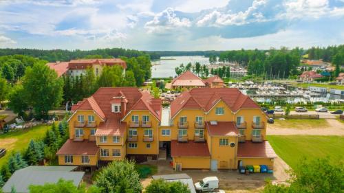 una gran casa amarilla con techo rojo en Hotel Helena, en Giżycko