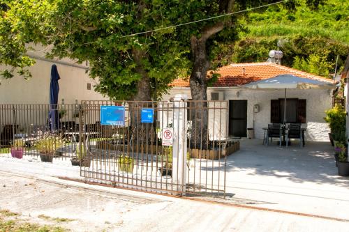 a fence in front of a house with a tree at Summer House by the Sea in Chorefto