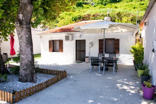 a patio with a table and an umbrella at Summer House by the Sea in Chorefto