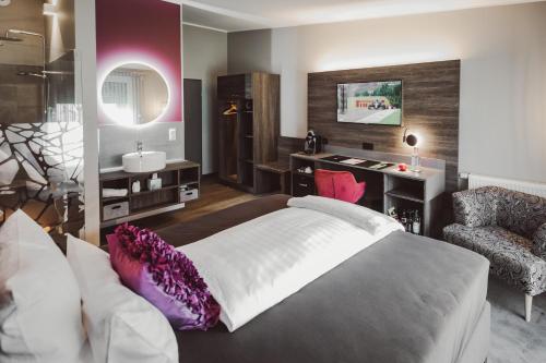 een slaapkamer met een bed, een bureau en een stoel bij Hotel Hildebrandt's in Neumünster