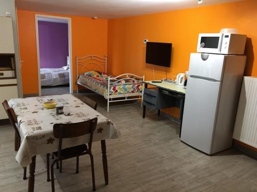 uma cozinha com uma mesa e um frigorífico num quarto em Gîte cosy à Ville-au-Val, proche Nancy et Metz, randonnées, 1 chambre, parking et terrain privé. - FR-1-584-111 em Ville-au-Val