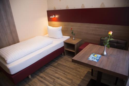 a small room with a bed and a table at Hotel City Panorama in Hannover