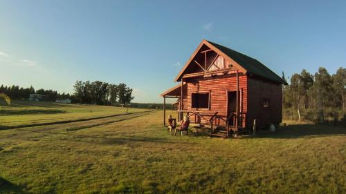 uma pequena casa de madeira num campo de relva em Centro Los Alamos em Maldonado