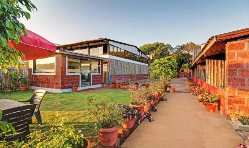 een tuin met potplanten en een gebouw bij Treebo La Paradise in Mahabaleshwar