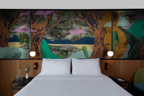 ein Schlafzimmer mit einem Bett und einem Wandbild von Bäumen in der Unterkunft Drawing House in Paris