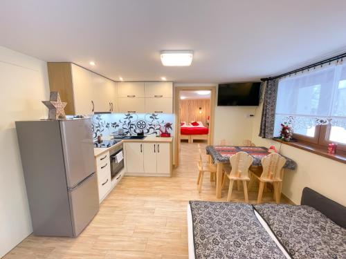 a kitchen and dining room with a refrigerator and a table at Apartament Jagodzianka Biały Dunajec in Biały Dunajec