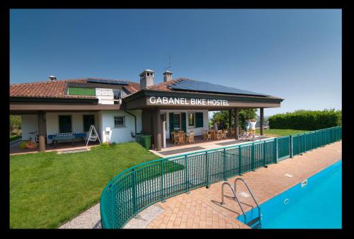 ein Gebäude mit einem Pool davor in der Unterkunft Gabanel Bike Hostel in Bussolengo