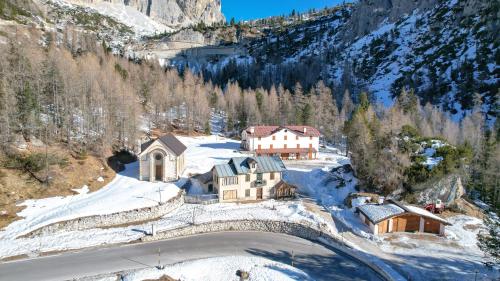 uma vista aérea de uma casa na neve em Hotel Al Sasso di Stria em Andraz