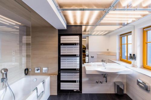 a bathroom with a tub and a sink and a bath tub at Rübezahlbaude in Großschönau