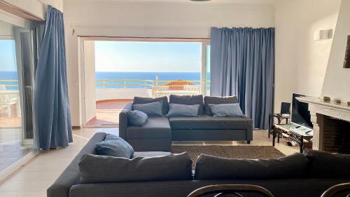 sala de estar con sofá y vistas al océano en Ericeira Panoramic Sea View Apartments, en Ericeira