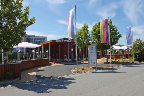 eine Straße mit Flaggen vor einem Gebäude in der Unterkunft SEETELHOTEL Nautic Usedom Hotel & Spa in Ostseebad Koserow