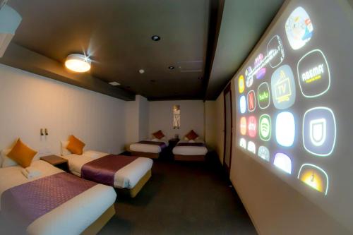 a hotel room with two beds and a wall with signs at Hotel S-Presso West - Vacation STAY 9085 in Osaka