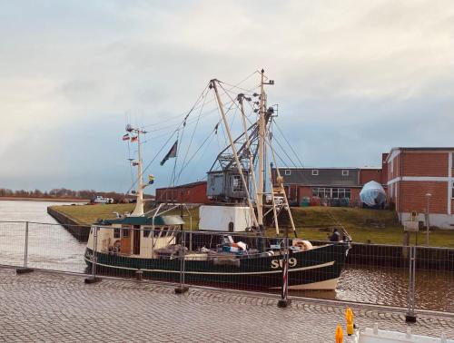 ein kleines Boot ist im Wasser angedockt in der Unterkunft Gasthaus Hafenblick in Tönning