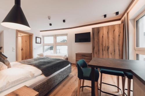 um quarto com uma cama, uma secretária e uma mesa em Alpenheim Apartment Ischgl em Ischgl