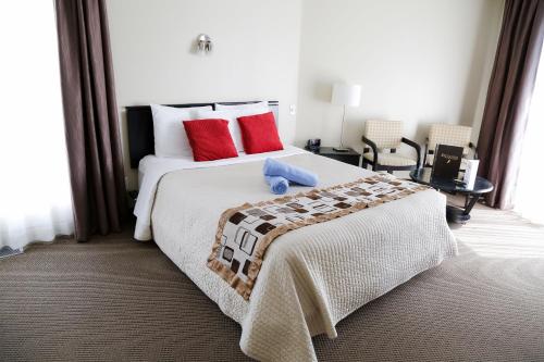 a bedroom with a large white bed with red pillows at Excelsior Hôtel Spa Sainte-Adèle in Sainte-Adèle