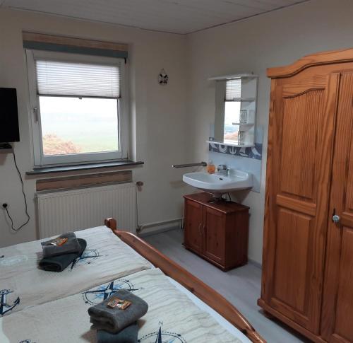 - une chambre avec 2 lits jumeaux et un lavabo dans l'établissement Gästehaus Mia, à Norddeich