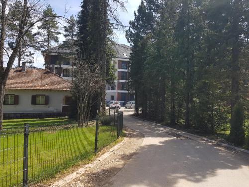 una carretera frente a una casa con una valla en SunStone Apartment, en Zlatibor